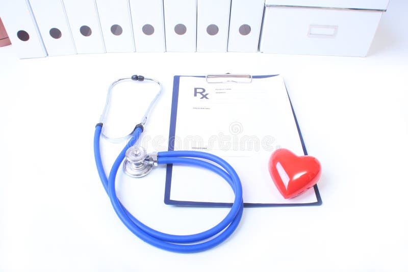 Closeup of medical stethoscope on a rx prescription, red heart on white background