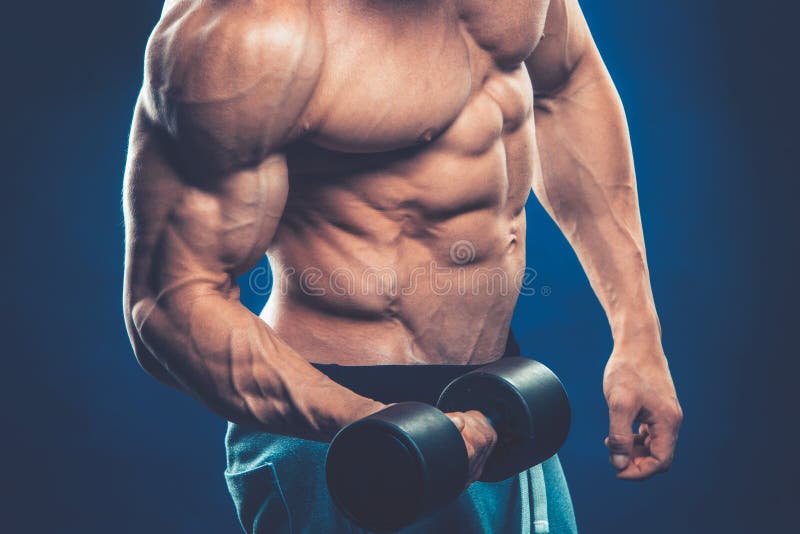 Closeup of a muscular young man lifting dumbbells weights on dar stock image Closeup of a muscular young man lifting dumbbells weights on dar stock image