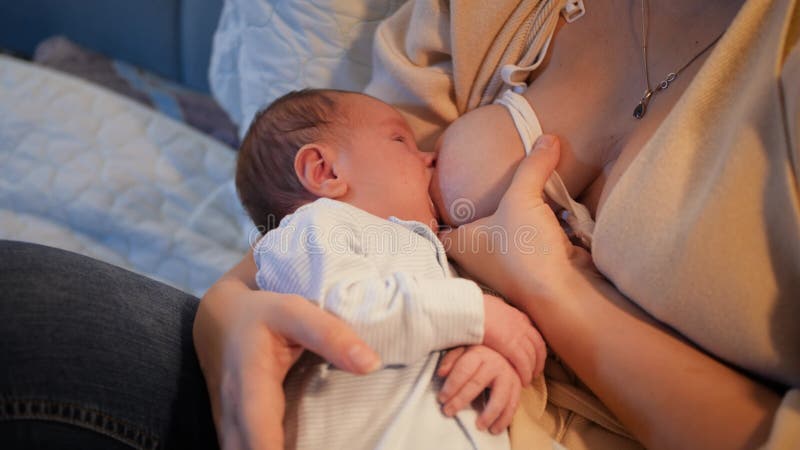 Closeup of Newborn Baby Eating Milk and Sucking Mothers Breast on Bed at Night. Concept of Healthy and Natural Baby Stock Footage - Video of evening, female: 208000994