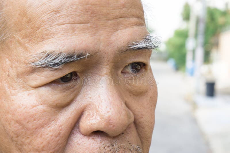Closeup old asian man`s eye and eyebrow. with copy space for text.