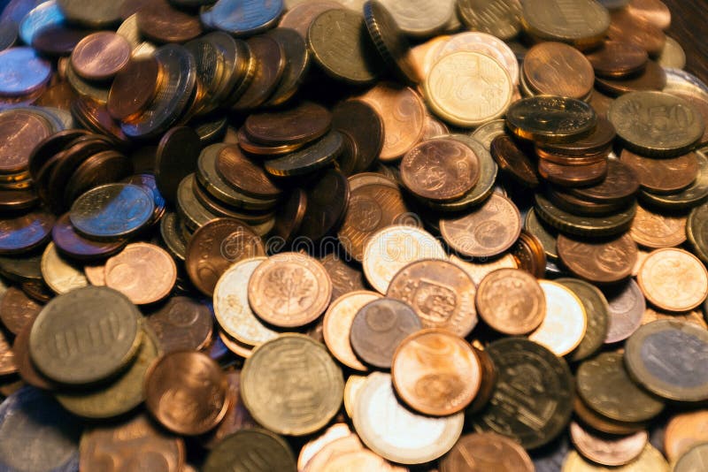 Closeup of old coins on the table under light with a blurry background.