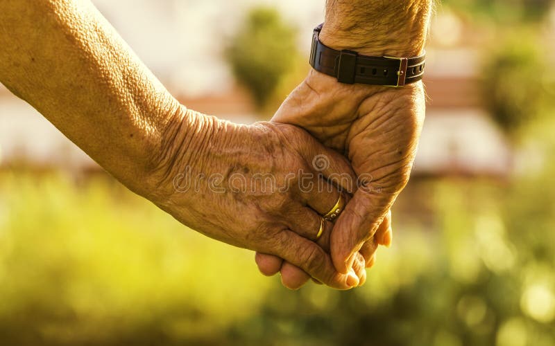 closeup-old-couple-holding-hands-under-s