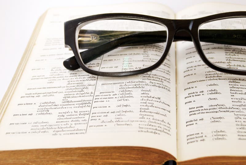 Closeup of old dictionary and glasses royalty free stock photos
