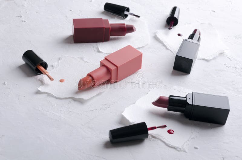 Closeup of opened lipsticks, brushes of nail polish on the white pieces of paper stock images Closeup of opened lipsticks, brushes of nail polish on the white pieces of paper stock images