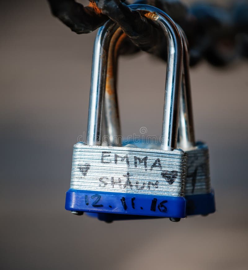 Closeup of a Padlock Hanging on Chain Link of the Bridge / Fence Stock