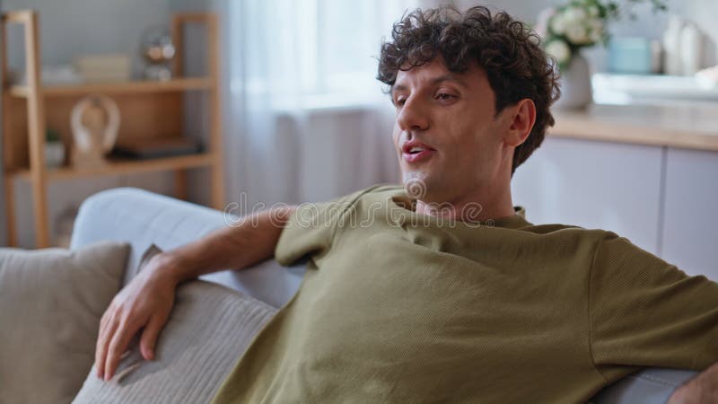 Closeup paresseux mec tomber canapé se décontracter à la maison. homme souriant de bonne humeur photos libres de droits