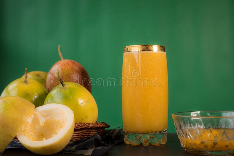 Closeup of passion fruits with a glass of juice on a table