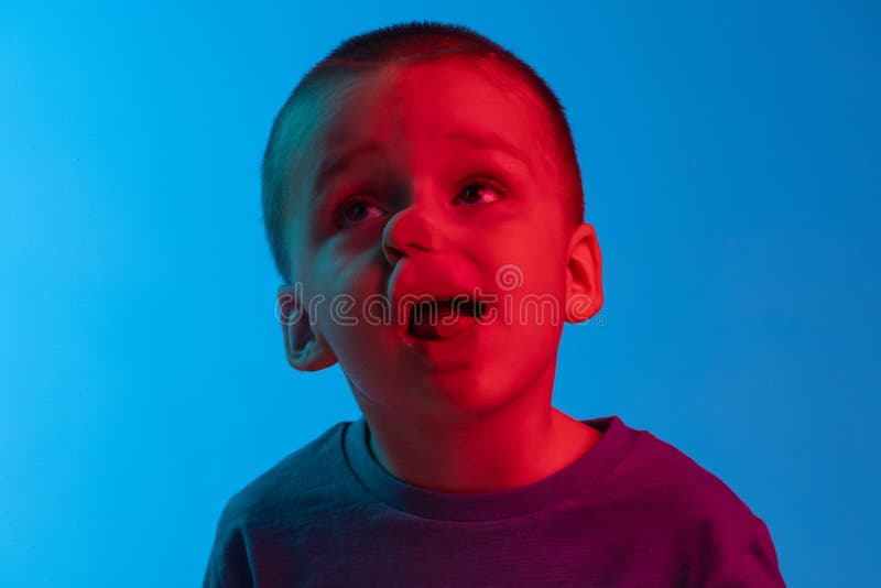 Closeup De Petit Garçon Penché Sur Le Verre Transparent Par Joue Isolée Sur  Fond Bleu Dans La Lumière Néon. Drôle De Visage Image stock - Image du  gibier, émotion: 257059493