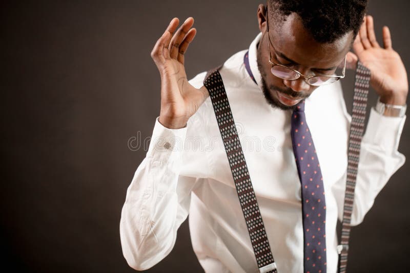 Closeup photo of african groom putting on slenders before wedding stock images Closeup photo of african groom putting on slenders before wedding stock images