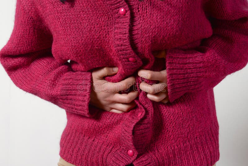 Closeup photo. a woman has a pain in her stomach, and holds her hands. Concept of female medicine. Digestive problems, gynecology royalty free stock image Closeup photo. a woman has a pain in her stomach, and holds her hands. Concept of female medicine. Digestive problems, gynecology royalty free stock image