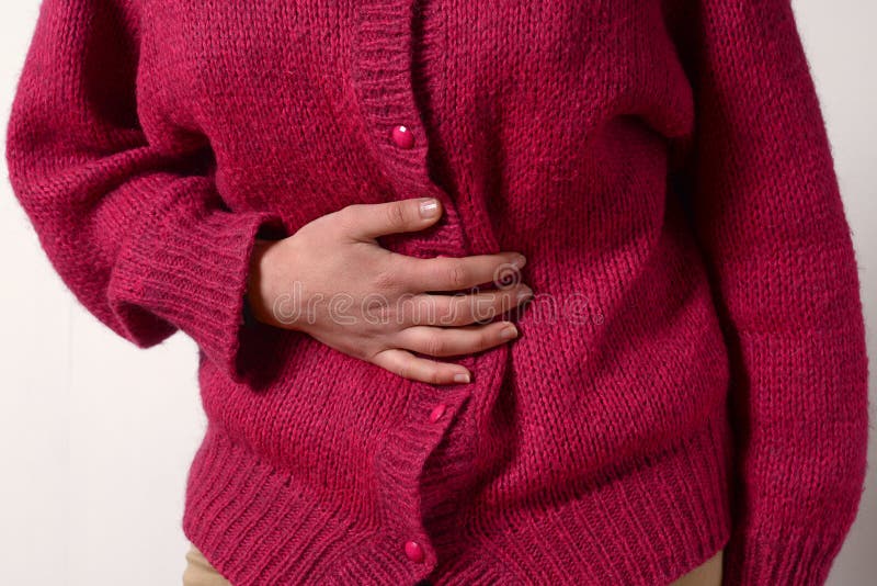Closeup photo. a woman has a pain in her stomach, and holds her hands. Concept of female medicine. Digestive problems, gynecology stock photo Closeup photo. a woman has a pain in her stomach, and holds her hands. Concept of female medicine. Digestive problems, gynecology stock photo