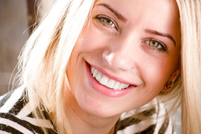 Closeup picture of beautiful blond young woman having fun happy smiling showing great dental whitening teeth