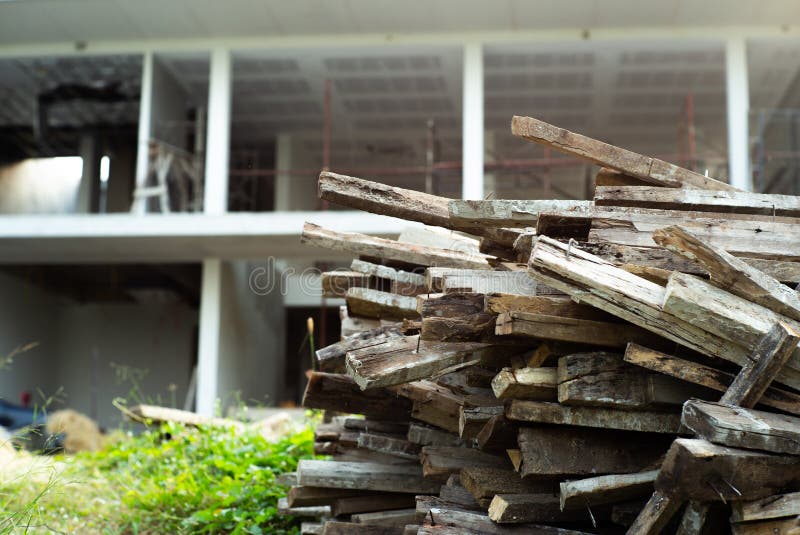 Closeup Pile of Wood with Blurred House Under Construction in