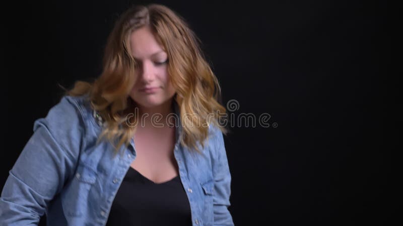 Closeup portrait of adult caucasian blonde female making funny dance moves in front of the camera