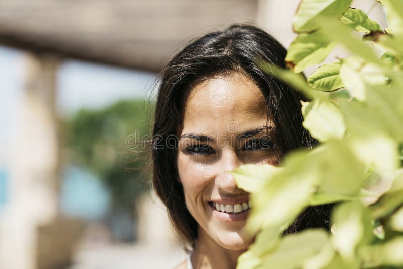 Closeup portrait of a beautiful hispanic woman in blue dress looking camera