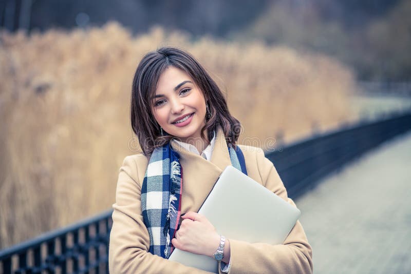 Closeup portrait of beautiful smiling college student look happy studying holding a tablet pad laptop at college park outdoors stock photography Closeup portrait of beautiful smiling college student look happy studying holding a tablet pad laptop at college park outdoors stock photography