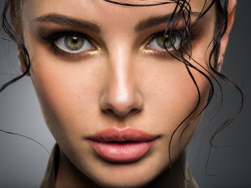 Closeup portrait of a beautiful young woman with brown gkamour makeup. Model looking at camera