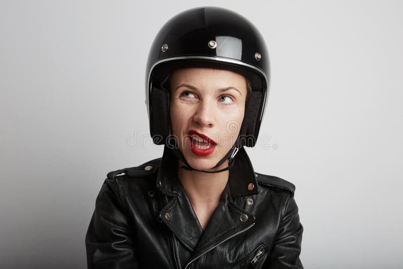 Closeup portrait of biker woman over white background, wearing stylish black sportive helmet and leather jacket.