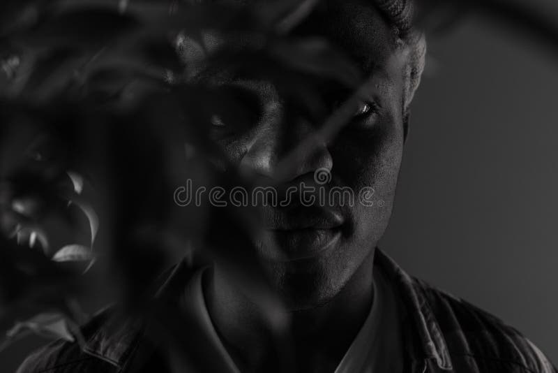 Closeup portrait of a black american man with big lips in black and white light in smoke.