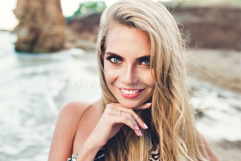 Closeup Portrait Of Pretty Blonde Girl With Long Hair Posing On Rocky Beach She Is Smiling To 