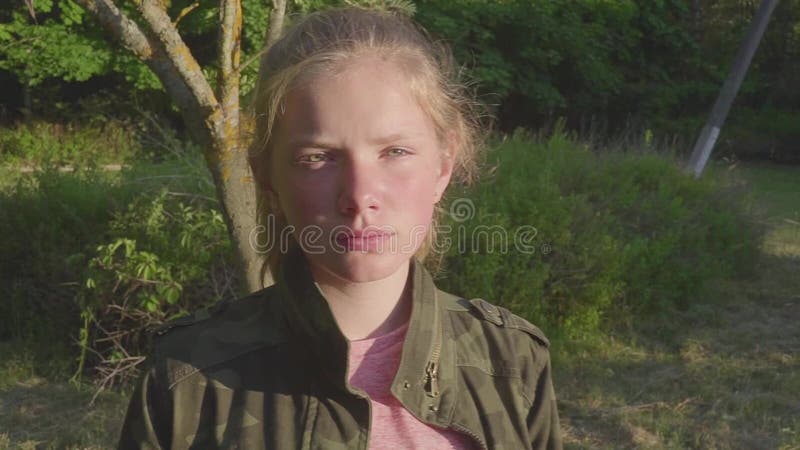 Closeup portrait of pretty teenage sad girl looking at camera. White happy smiling kid with natural blonde long hair