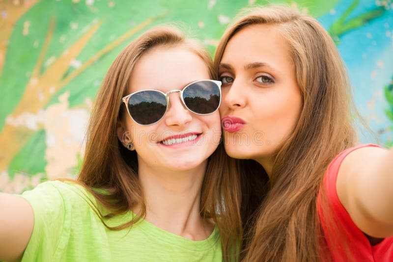 Closeup portrait of two teenage girls friends in hipster outfit royalty free stock photography Closeup portrait of two teenage girls friends in hipster outfit royalty free stock photography