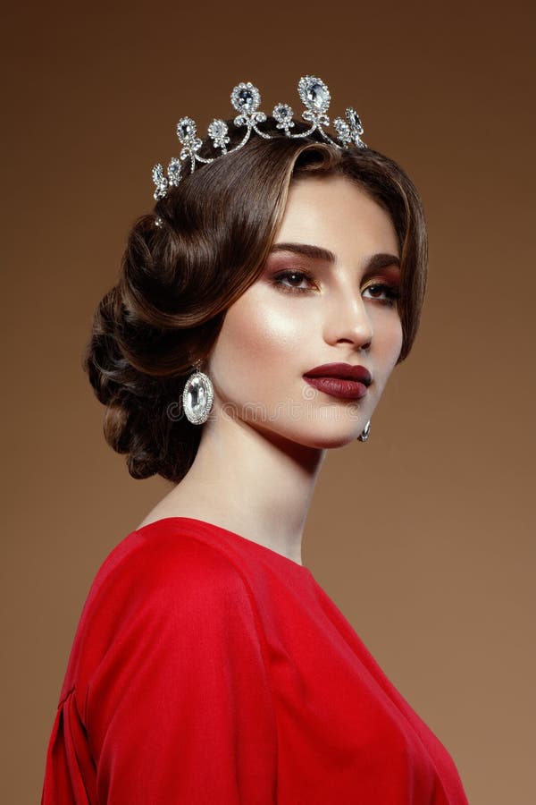 Closeup portrait of young woman, diamond crown and earring. Brunette gorgeous woman, on a beige background. stock photos Closeup portrait of young woman, diamond crown and earring. Brunette gorgeous woman, on a beige background. stock photos