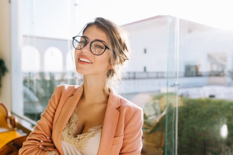 Closeup portrait of young woman wearing stylish glasses, smart lady in elegent pink jacket with beige blouse, cute