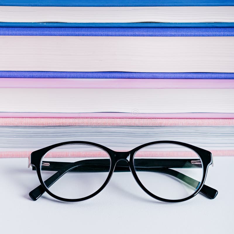 Closeup Of Reading Glasses Against Pink And Purple Stack Of Books Book 