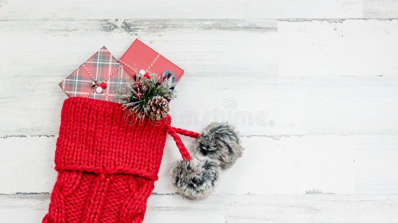 Closeup of red knit Christmas stocking on white wood background