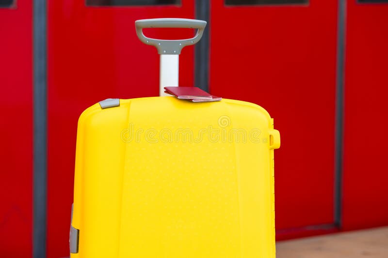 Closeup red passports on yellow luggage at train