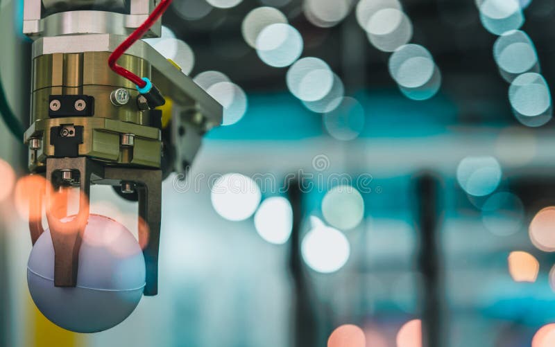 Closeup robot hand machine picking up white ball on bokeh blurred background. Use smart robot in manufacturing industry. Robotic royalty free stock images Closeup robot hand machine picking up white ball on bokeh blurred background. Use smart robot in manufacturing industry. Robotic royalty free stock images