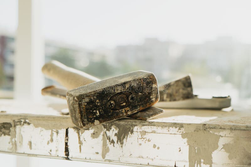 A metal mallet and a chisel on a working platform stock images