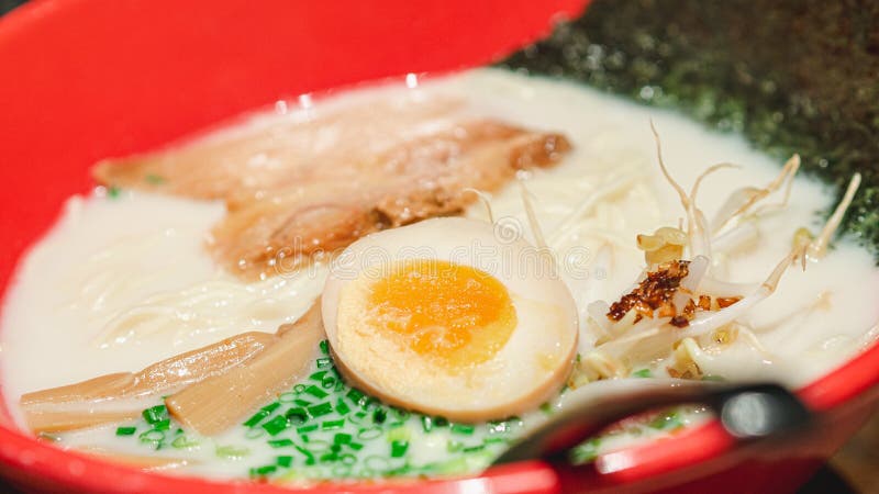 Closeup Shio or Salt-Flavored white soup ramen in a red bowl.