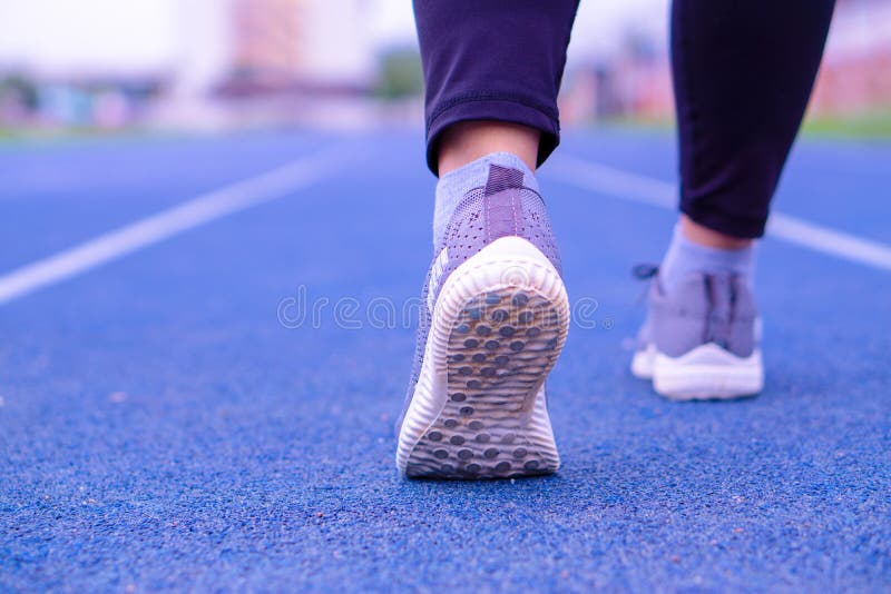 Closeup shoe. Female legs jogging and walking on the running track. Sport and exercise concept