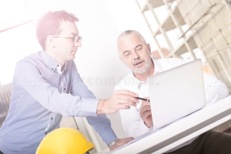 Closeup shot of an architect discussing the project with his male assistant royalty free stock image