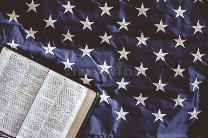 Closeup shot of the Bible open in pages put on the American flag - perfect for praying concept