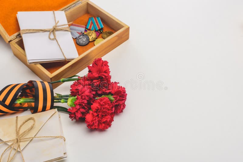 closeup shot of box with medals, stacks of letters, carnations wrapped by st. george ribbon on gray, victory day concept stock images closeup shot of box with medals, stacks of letters, carnations wrapped by st. george ribbon on gray, victory day concept stock images