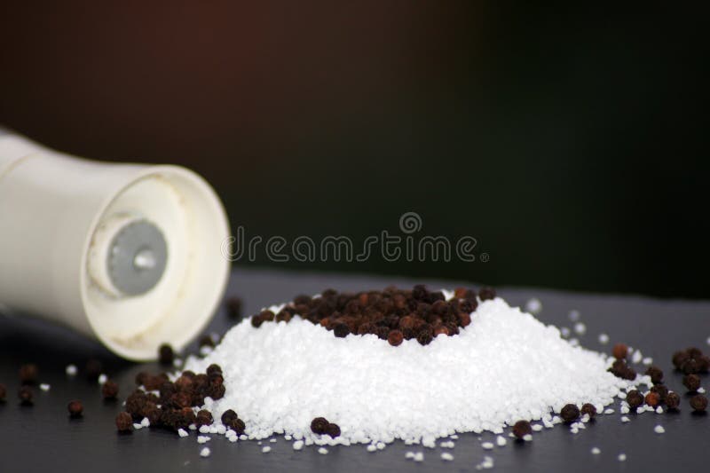 Closeup Shot of Coarse Salt and Pepper Grains on a Smooth Surface Stock