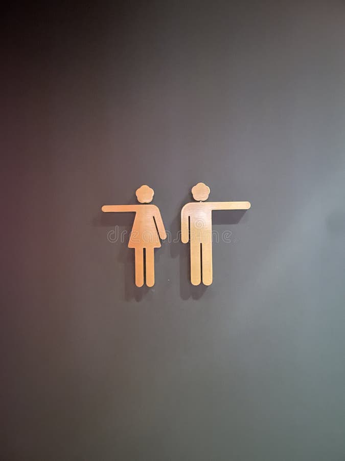 Closeup shot of a creative pointing toilet sign royalty free stock photography