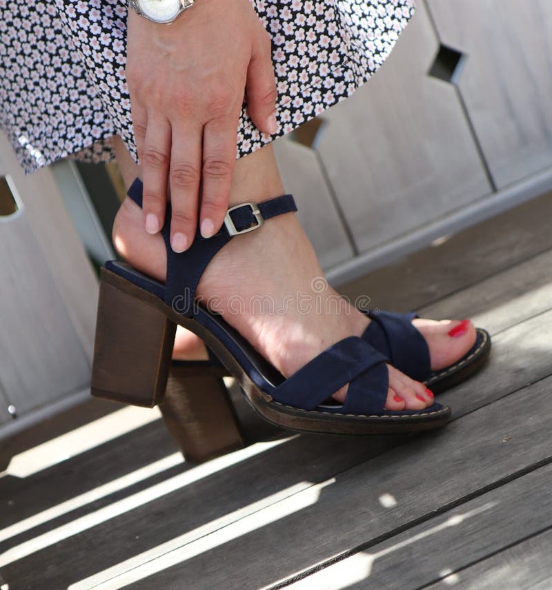 Closeup shot of elegant feet of a female wearing a dress at Summer stock photo Closeup shot of elegant feet of a female wearing a dress at Summer stock photo