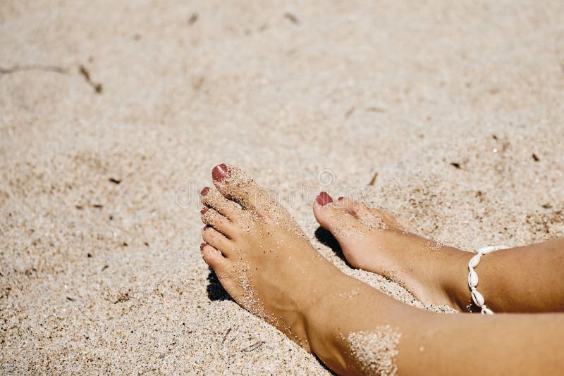 Closeup Shot of a Females Feet in a Sandy Ground with a Blurred ...
