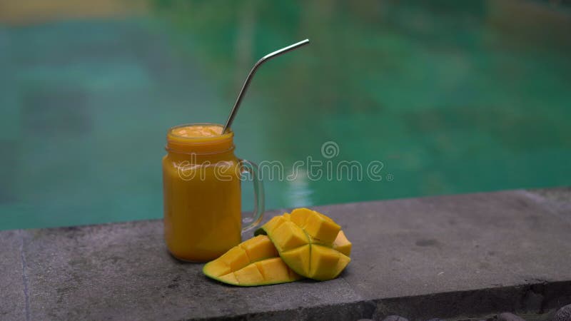 Closeup Shot of a Glass of a Mango Shake and Cut Mangoes on a Side of a ...