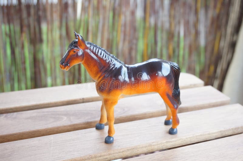 Closeup shot of a plastic horse toy on a wooden surface with a blurred background. A closeup shot of a plastic horse toy on a wooden surface with a blurred stock images Closeup shot of a plastic horse toy on a wooden surface with a blurred background. A closeup shot of a plastic horse toy on a wooden surface with a blurred stock images