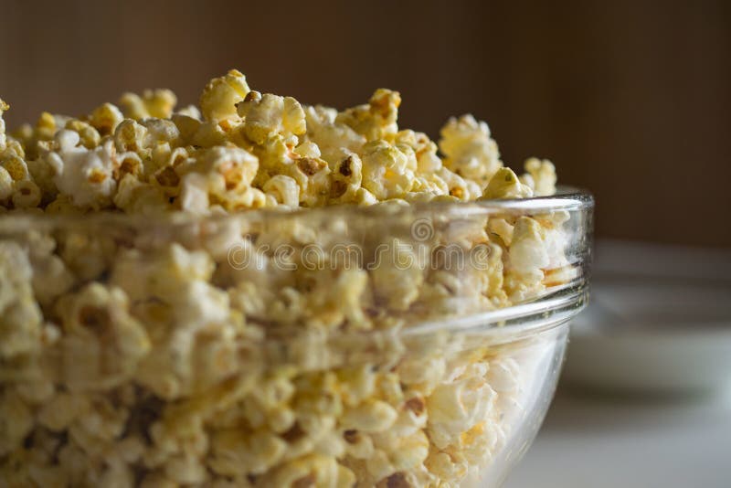 Closeup shot of popcorn in a glass bowl with a blurred background stock images Closeup shot of popcorn in a glass bowl with a blurred background stock images