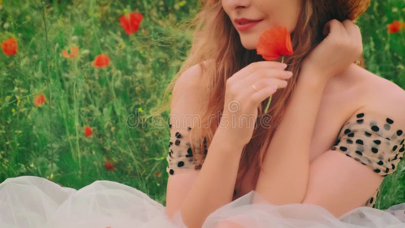 Closeup shot portret szczęśliwa kobieta spacerująca skórą i wargami z czerwonym kwiatem maku zbiory