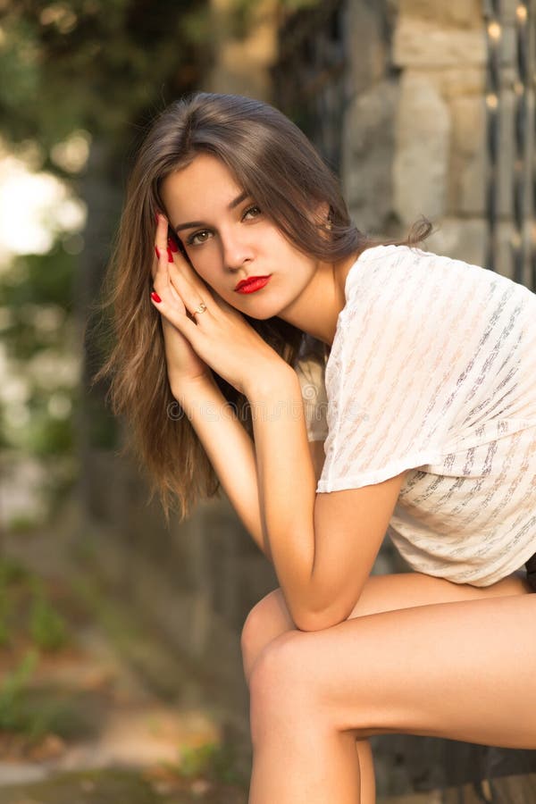 Closeup shot of pretty brunette girl with red lips posing on a g