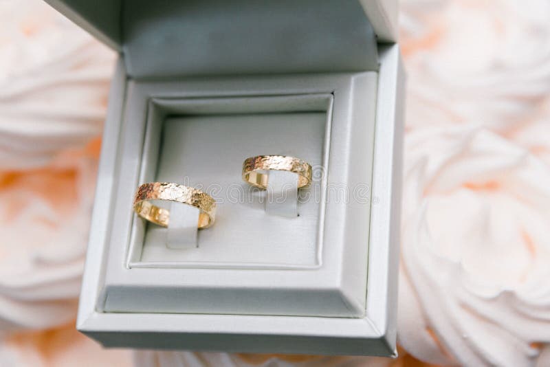 Closeup Shot of Two Golden Wedding Rings in a White Box Stock Image