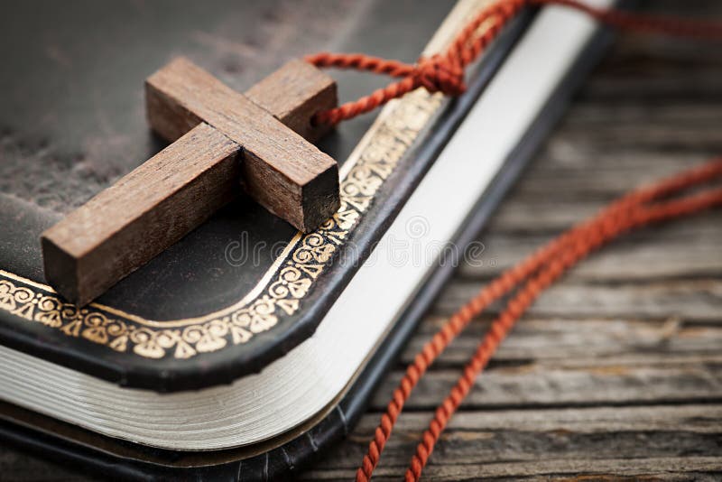 Closeup of simple wooden Christian cross necklace on holy Bible. Closeup of simple wooden Christian cross necklace on holy Bible