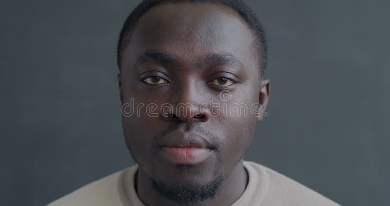 Closeup slow motion portrait d'un Africain-Américain sérieux regardant la caméra sans émotion clips vidéos